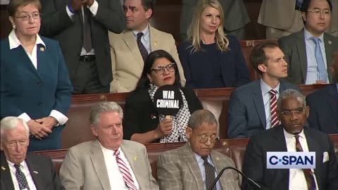 Rashida Tlaib holds a sign calling Israeli PM Netanyahu a "War Criminal" as he addresses Congress.