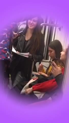 Girl yellow jacket eating pasta out of tupperware on subway