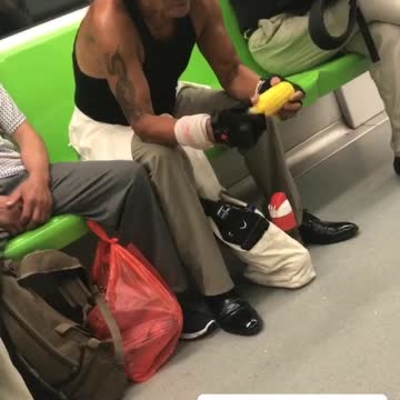 Man in hat eats corn on the cob in china