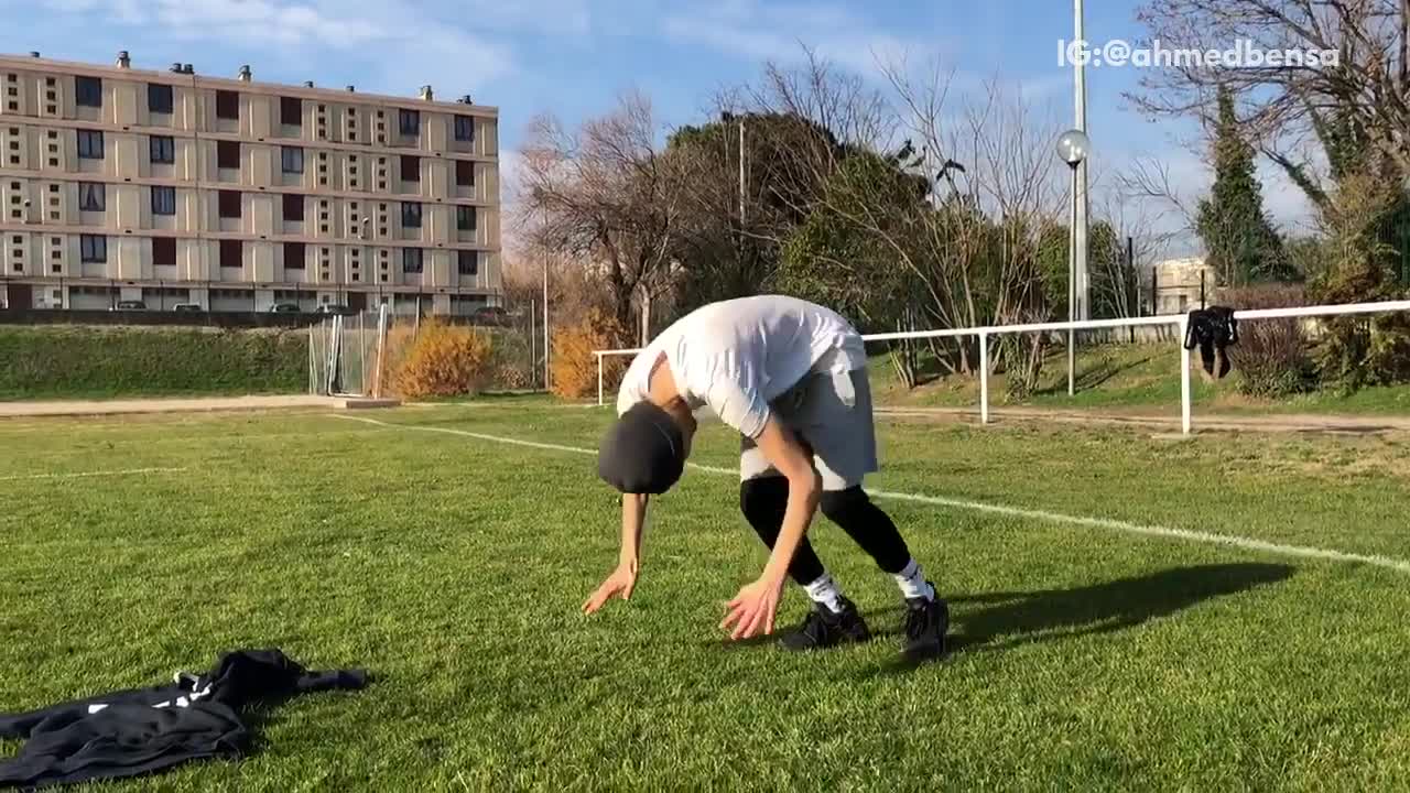 Beanie guy does front roll on grass soccer field