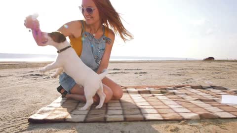 young stylish hipster playing dog puppy jack russell on the beach,