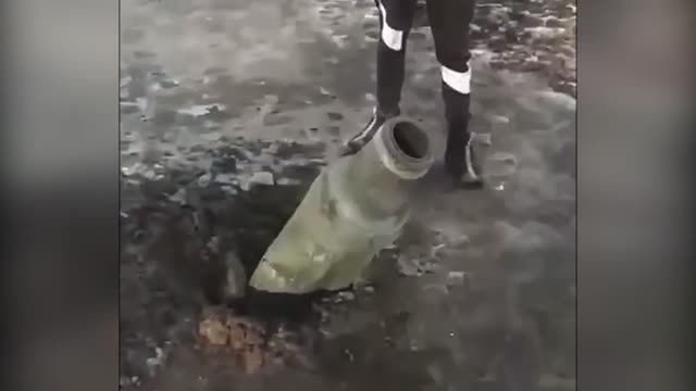 Ukrainian citizens surrounded an unexploded munition in the ground and kick it - madness 🇺🇦