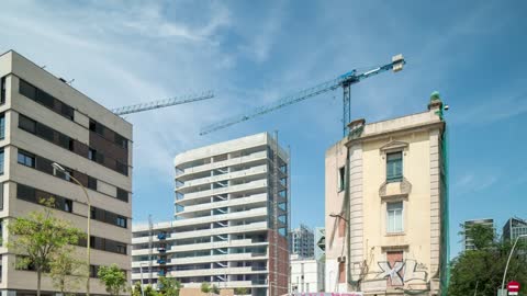 Bottom shot of city buildings and cranes