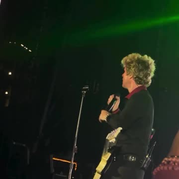 Green Day's Billie Joe Armstrong holds up a rubber Trump head