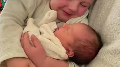 An older brother holds his baby sister for the first time. Tears flow ...