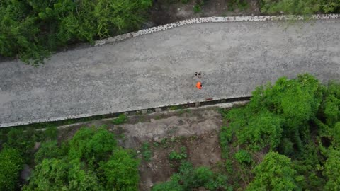 Two people walking down a road seen from above