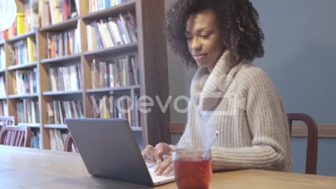 Casual student woman sitting at coffee shop and using laptop