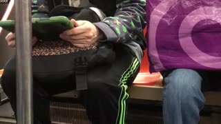 Man headphones green ipad dancing sitting subway train