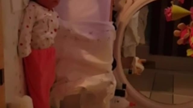 The baby is looking at the mobile