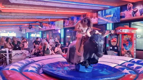 Pretty Girl in Beautiful Dress Riding on a Bull in Benidorm _ Mechanical Bull 4K. Epic Fail August