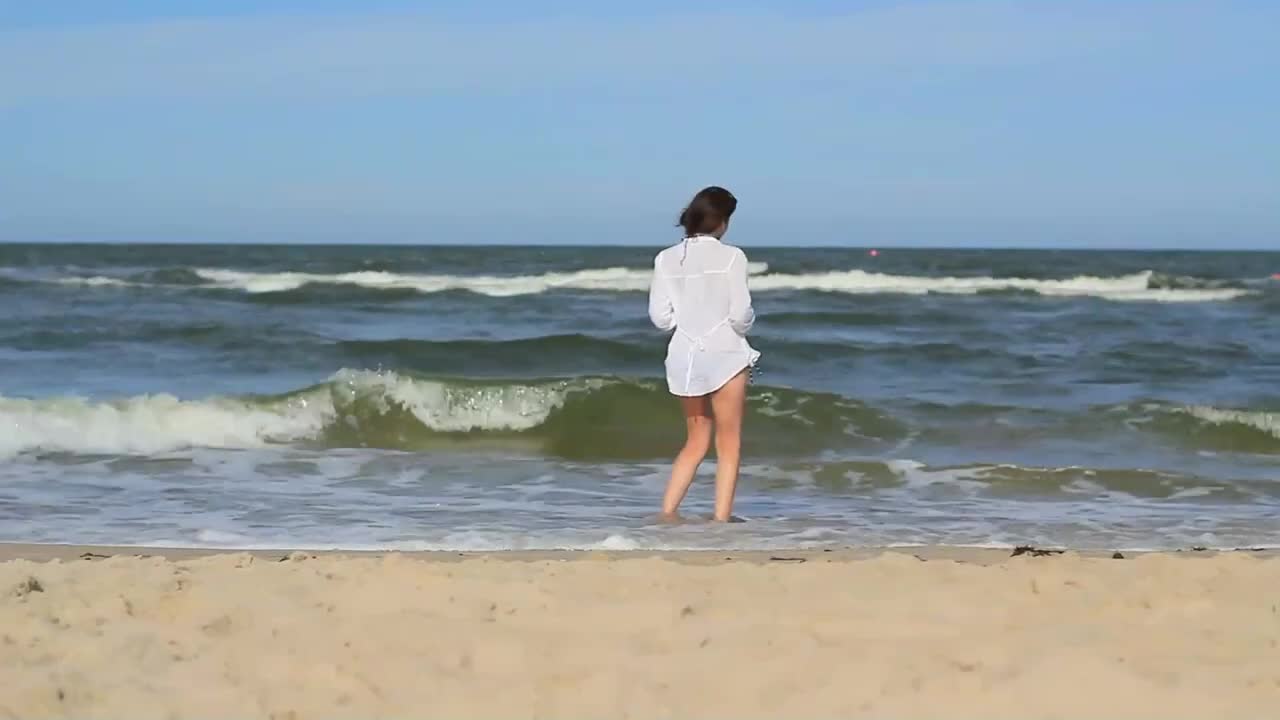 Beautiful girl in the waves of the ocean - summer vibes