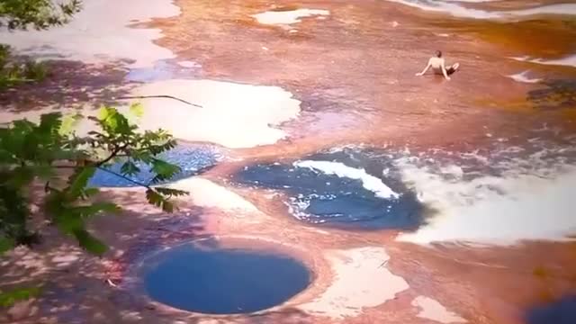 The water in this pothole is darker than the water flowing outside.