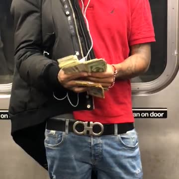 Man in red shirt counting a wad of money