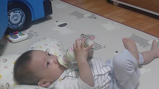 The baby is drinking milk powder himself.