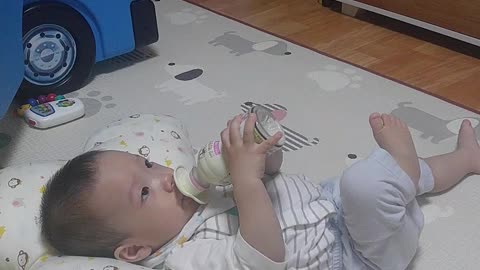 The baby is drinking milk powder himself.