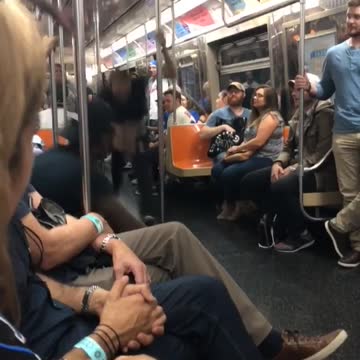 Man in black shirt swinging on subway poles