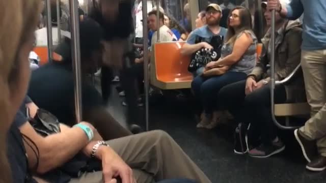 Man in black shirt swinging on subway poles