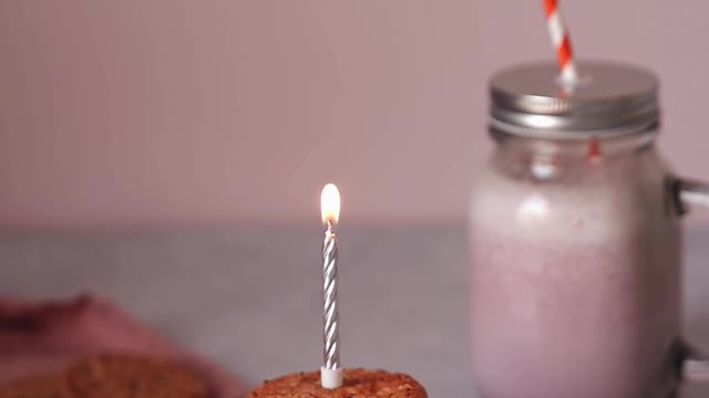 A Person Lighting a Candle on Top of the Cookie Sandwich