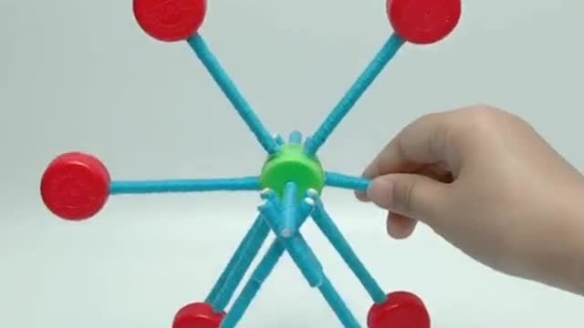 A Ferris wheel is built with wool, disposable chopsticks and accumulated bottle caps