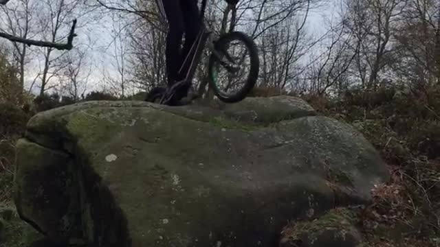 Guy tries to drive over rocks on bike falls forward into bush