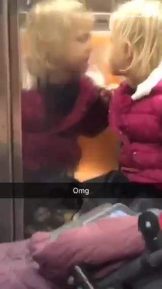 Little girl pink jacket licking her reflection wall