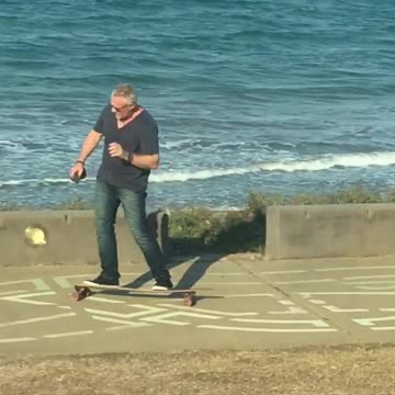 Commentary of dad grey white hair on phone riding by on longboard