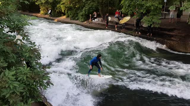 Man Surfing on artificial wave in munchen park