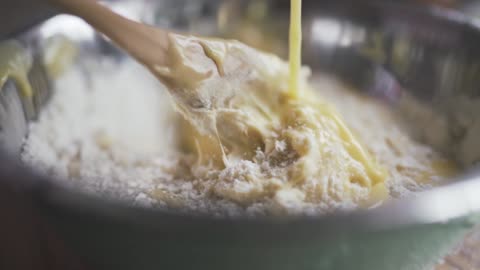 Stirring flour and condensed milk on a mixing bowl