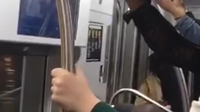 A person on train with green hand and pink nails