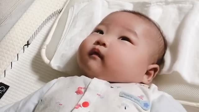 A baby lying down and charming