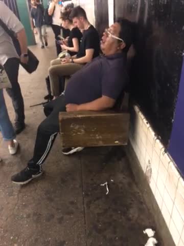 Man in purple shirt asleep on bench