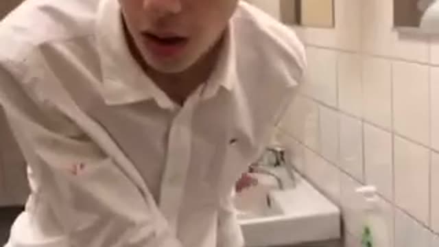 Drunk guy white shirt looking around restroom