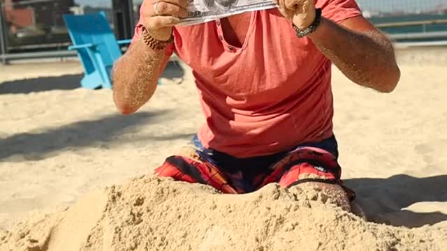 A Man Digging money from the sand oh shit