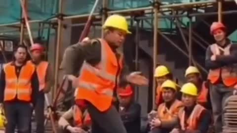 Construction worker performs a show, doing various dance steps