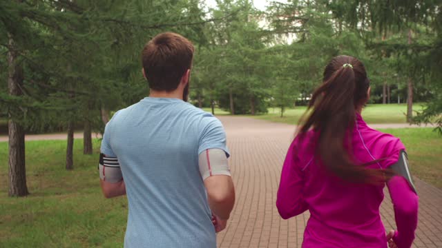 Backside Of A Man And Woman Jogging In A Park