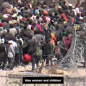 migrants rushing a portion of the US border fence in El Paso, Texas.