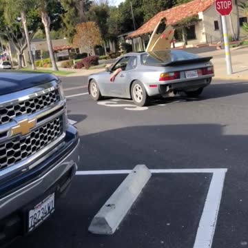 Guy drives by with two surfboards hanging outside his sunroof