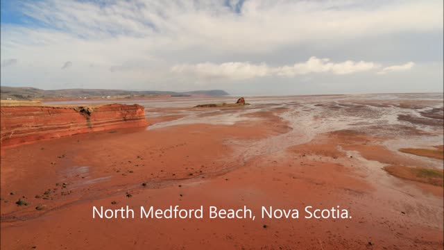 Red sand, blue skies, and white clouds