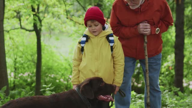 A Boy Patting His Pet while His Grandfather is looking