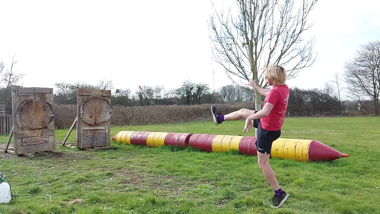 Guy Kicking an Axe off Foot While Throwing Another Landing Both