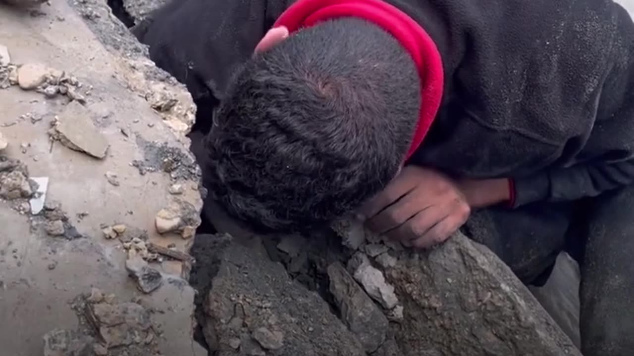 Palestinian man searches through rubble for family.