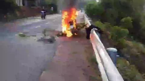 Tragic motorcycle accident on the road emitting smoke