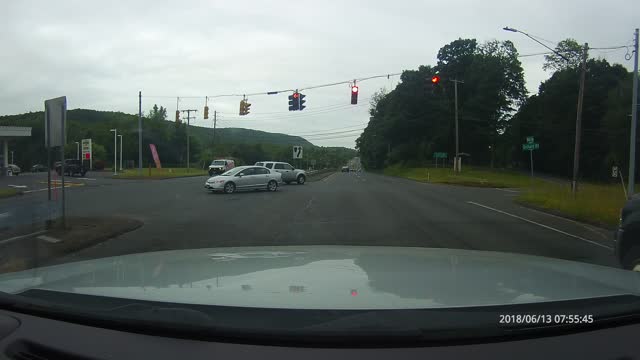 Impatient Car decides to run red light through crossing traffic