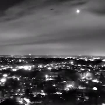 UFO being escorted through the sky by two Black Hawk helicopters.