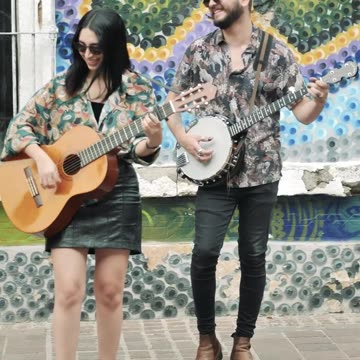 Young man and woman playing music on a colorful street