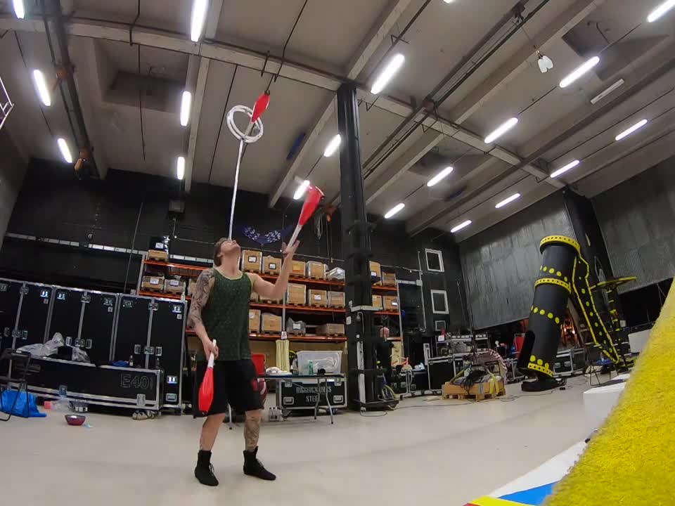 Guy Juggling Clubs While Balancing and Spinning a Ball on Forehead