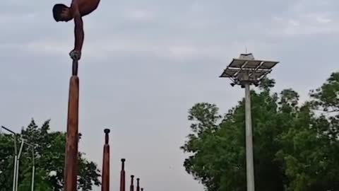 Guy Performs Backflip After Displaying Handstand On a Pole