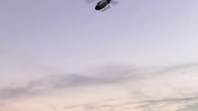 The helicopter turns overhead.
