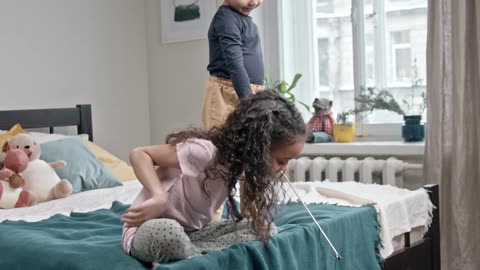 Kids Playing Catch The Bait With Their Cat In The Bedroom