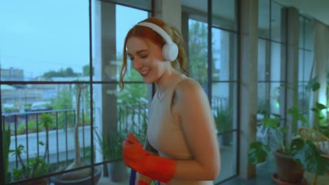 Woman cleaning her house dancing happy